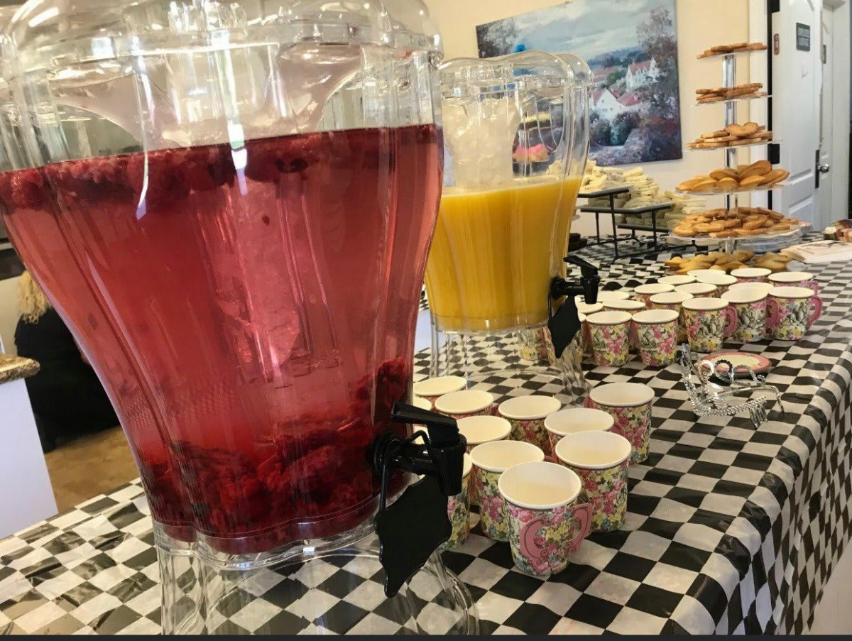 A buffet table with juice dispensers and cups ready for guests.