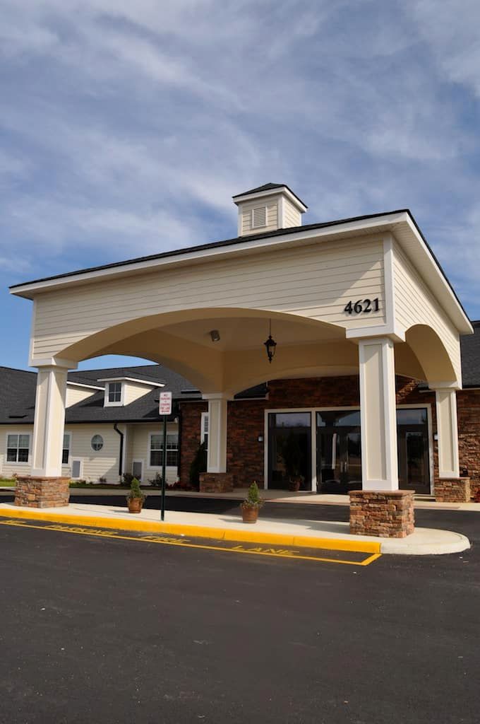 The front entrance of a building with a covered driveway.