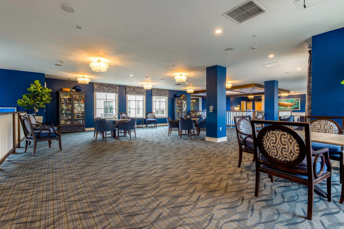 A spacious dining area with elegant furnishings and large windows.