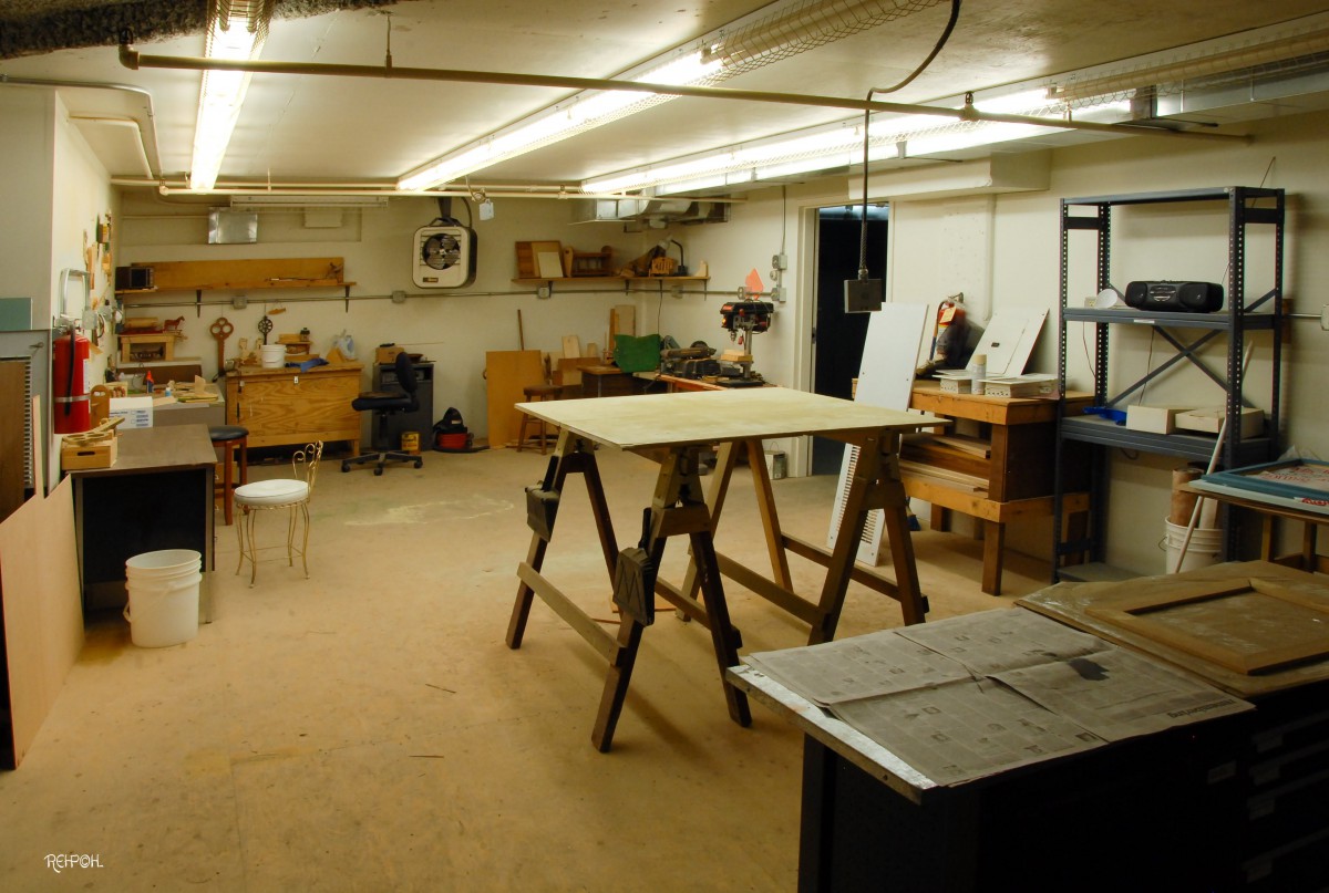 A well-organized woodworking workshop with various tools, workbenches, and equipment.