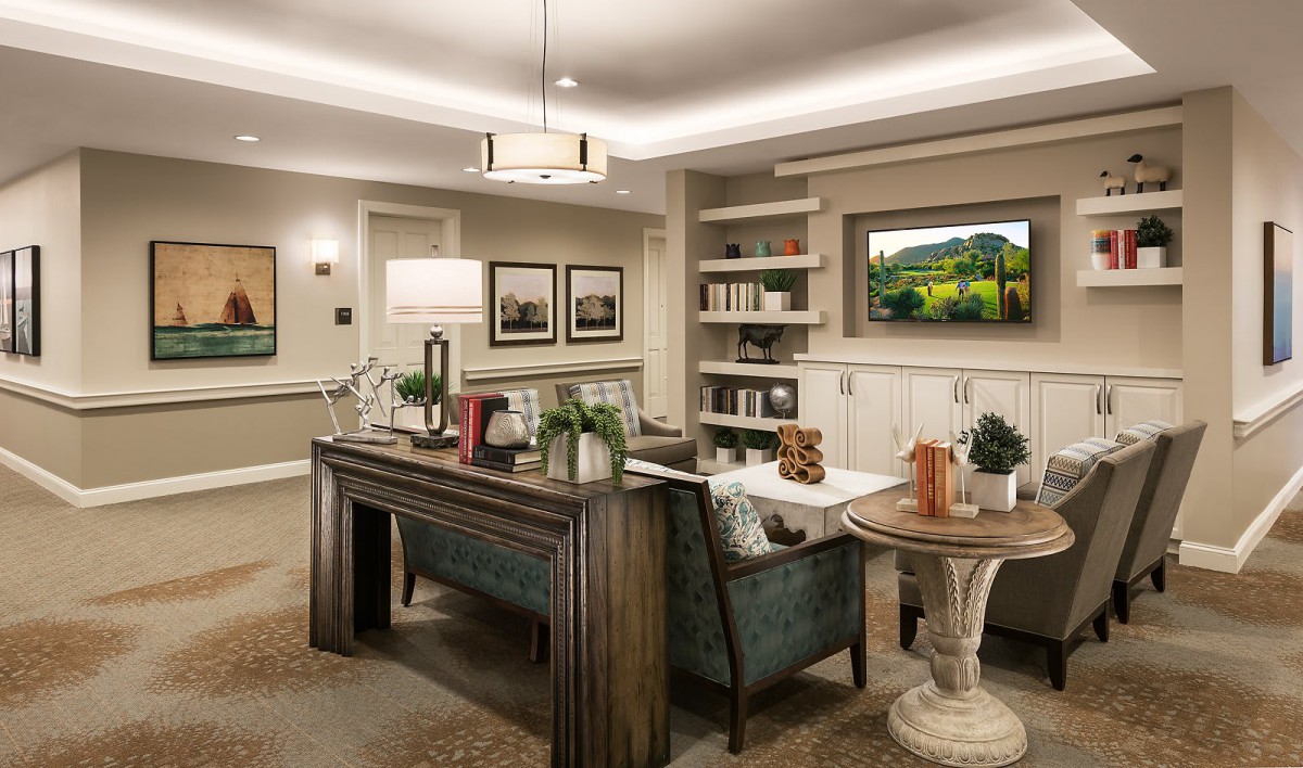 A cozy living room featuring elegant furniture, a bookshelf, and tasteful artwork.