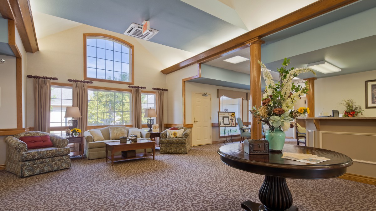 A cozy lobby area with comfortable seating and decorative flowers.