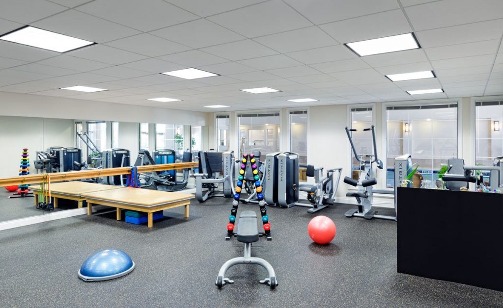 A spacious gym with various exercise equipment and workout stations.