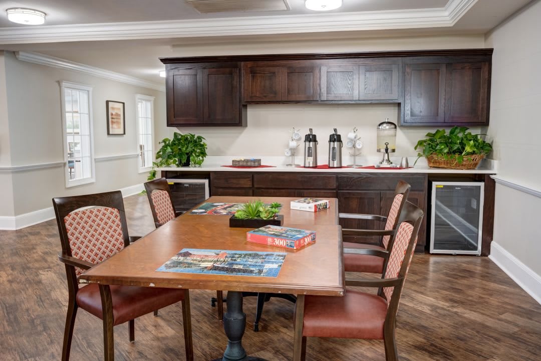 A cozy dining area with a wooden table, chairs, and a kitchen counter in the background.