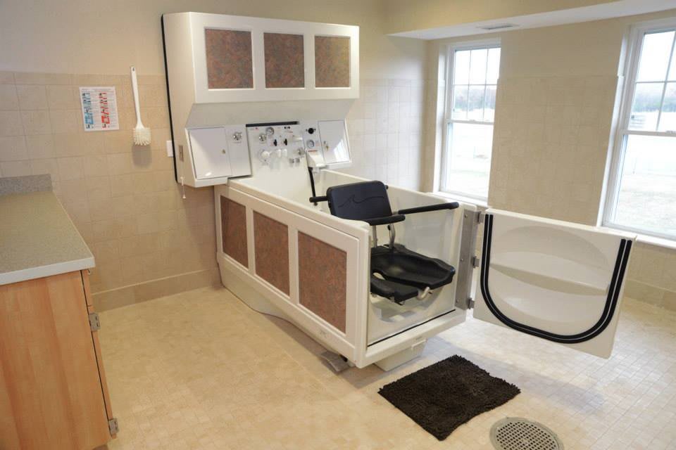 An accessible bathtub with a door and seat for easy entry in a modern bathroom.