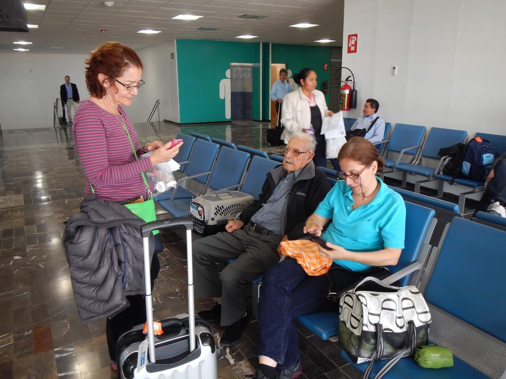 Travelers passing time in an airport waiting area.