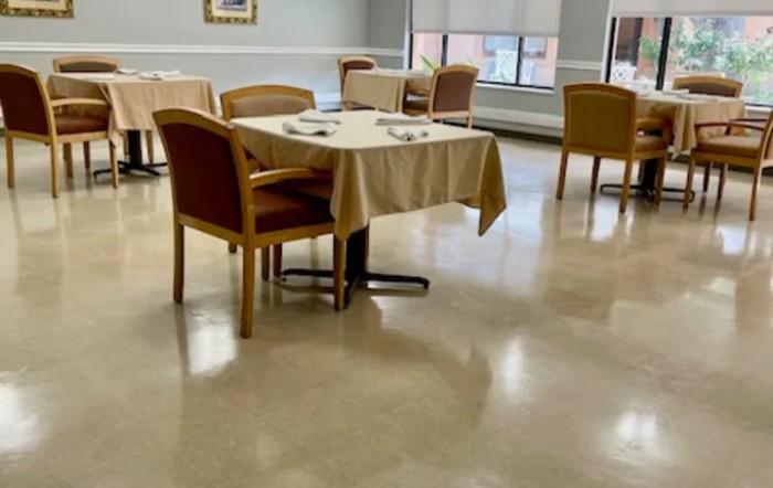 An empty dining room with neatly arranged tables and chairs.