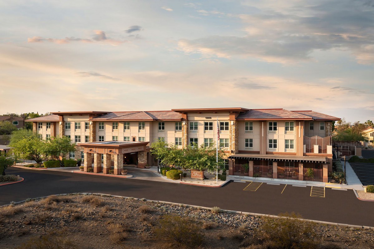 A scenic view of a desert hotel under a cloudy sky.