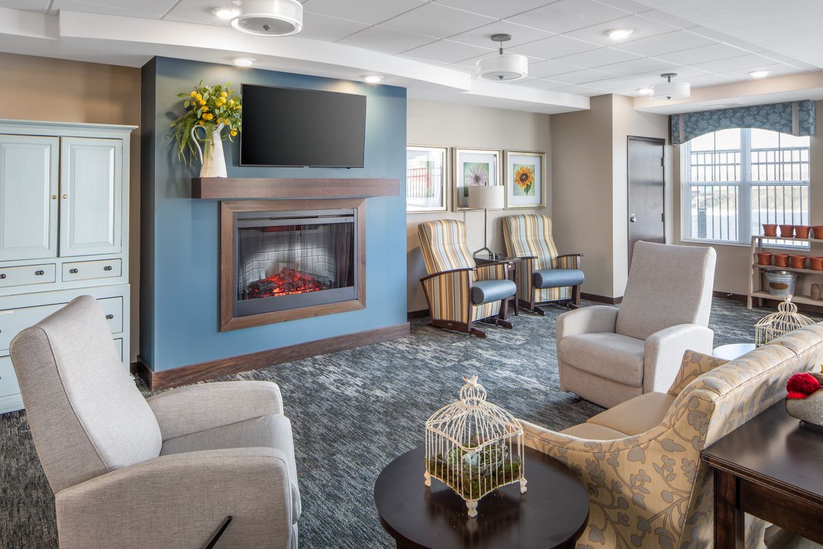 A modern lobby with a cozy seating area, featuring a fireplace and television.