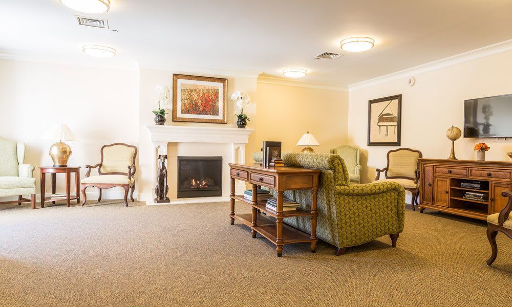 A cozy living room featuring a fireplace, elegant armchairs, and classic decor.