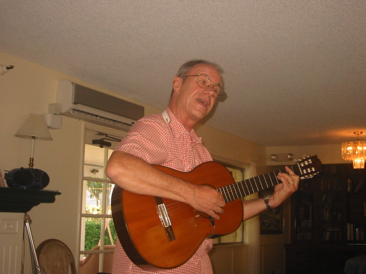 A man playing an acoustic guitar indoors.