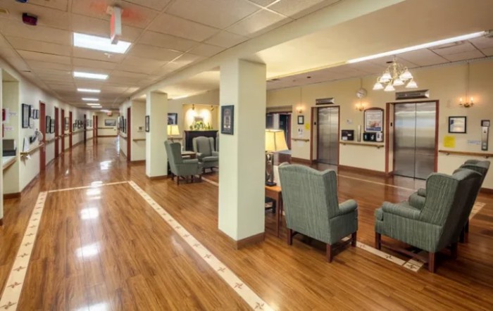 A spacious and well-lit lobby or waiting area with comfortable seating and wooden flooring.