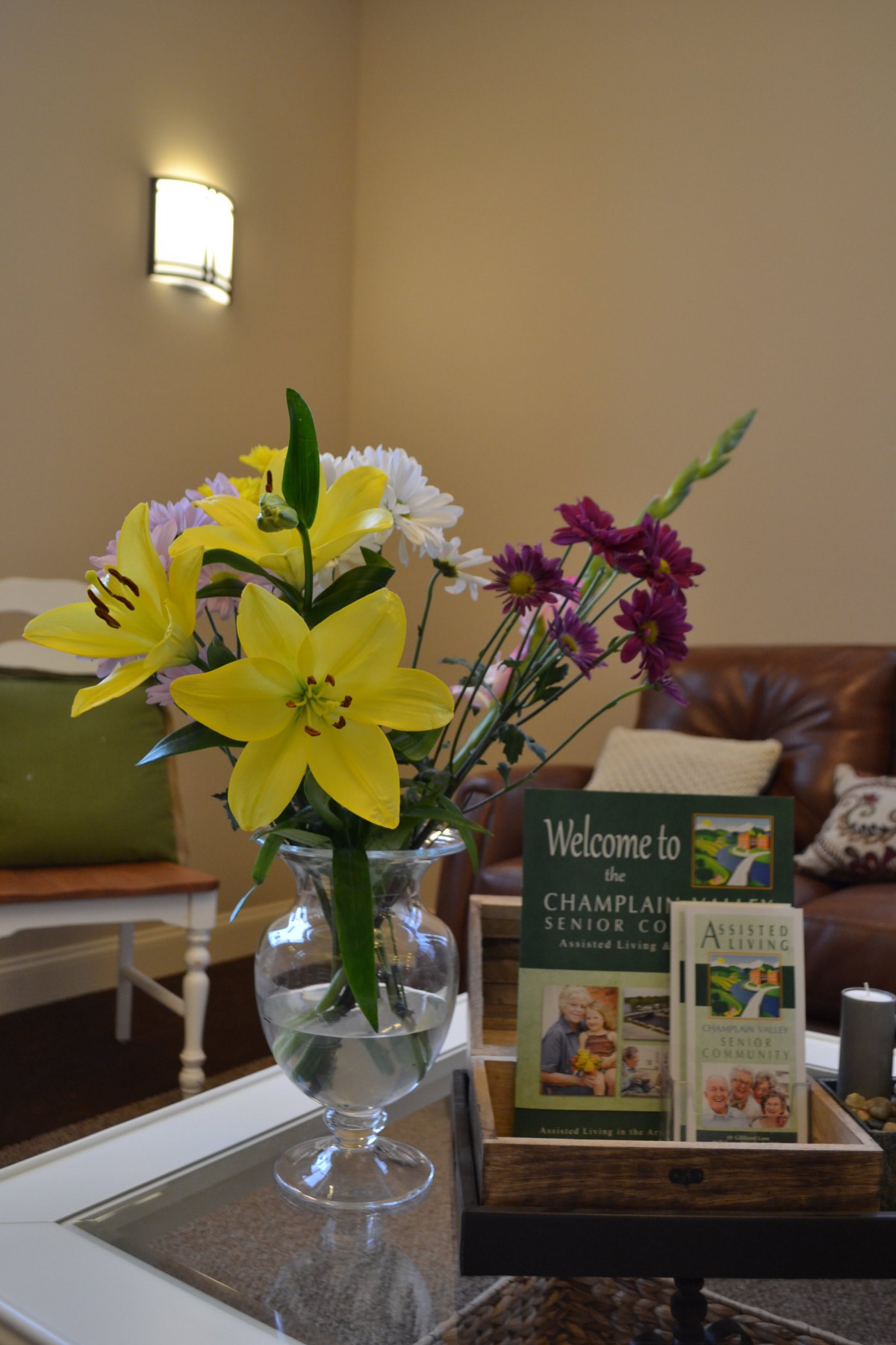 A cozy interior with a vase of colorful flowers alongside informational brochures.