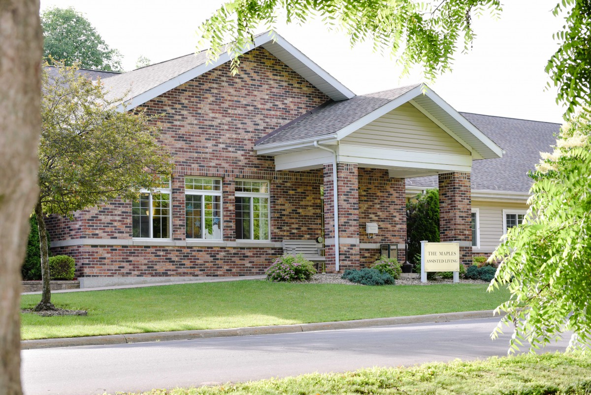 A brick building with a well-maintained lawn and shrubs.