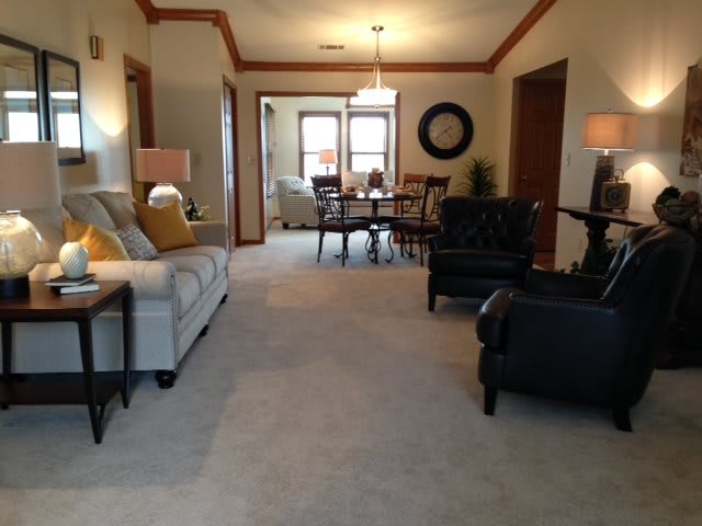 A spacious living and dining area featuring comfortable seating, warm lighting, and elegant decor.