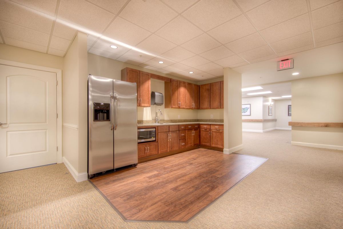 A modern kitchen setup with wooden cabinets and a stainless steel refrigerator.