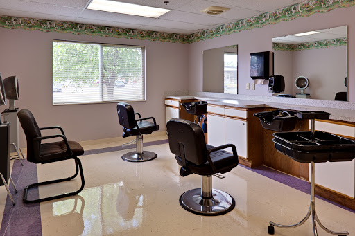 A clean and modern hair salon interior featuring styling chairs and large mirrors.