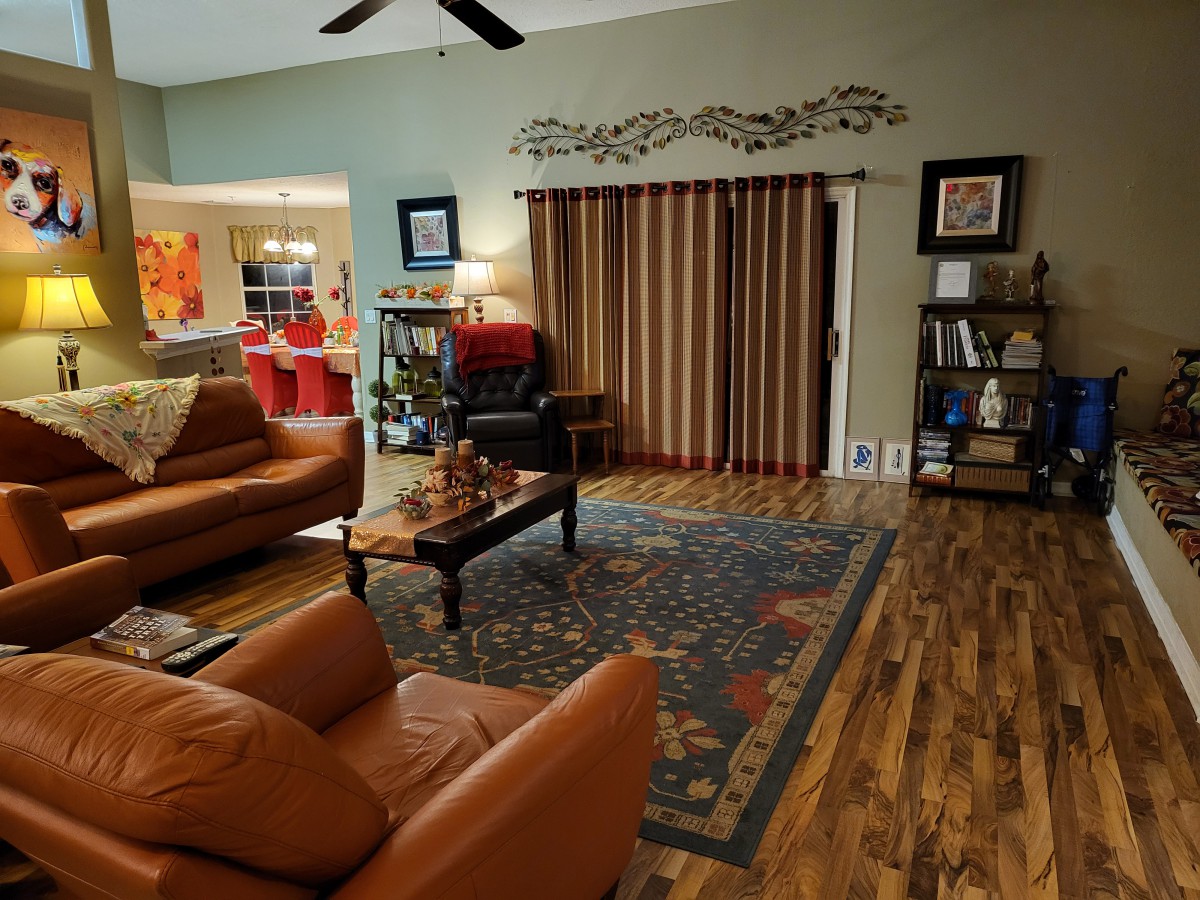 A cozy living room with leather sofas, a coffee table, and a decorative rug.