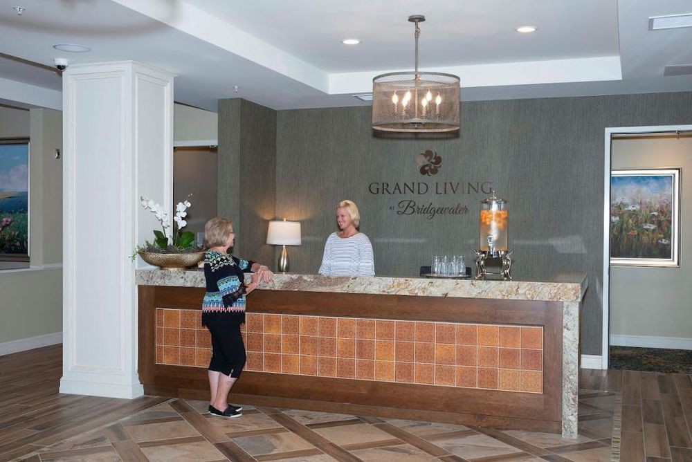 A hotel reception area with two people at the counter.