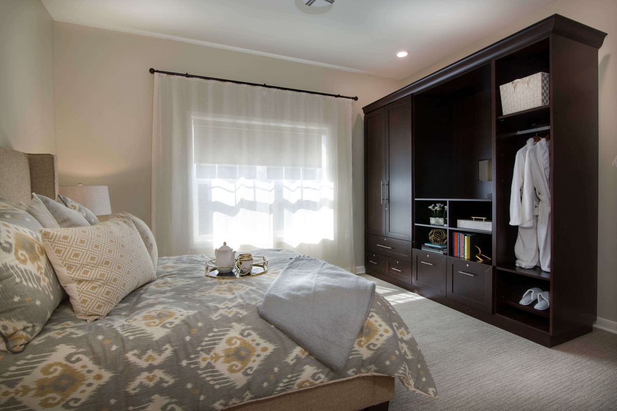 A cozy bedroom with a large bed and dark wood wardrobe.