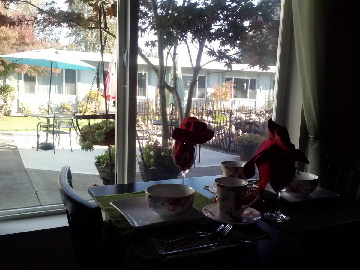 A cozy dining table with a view of the outdoor courtyard.
