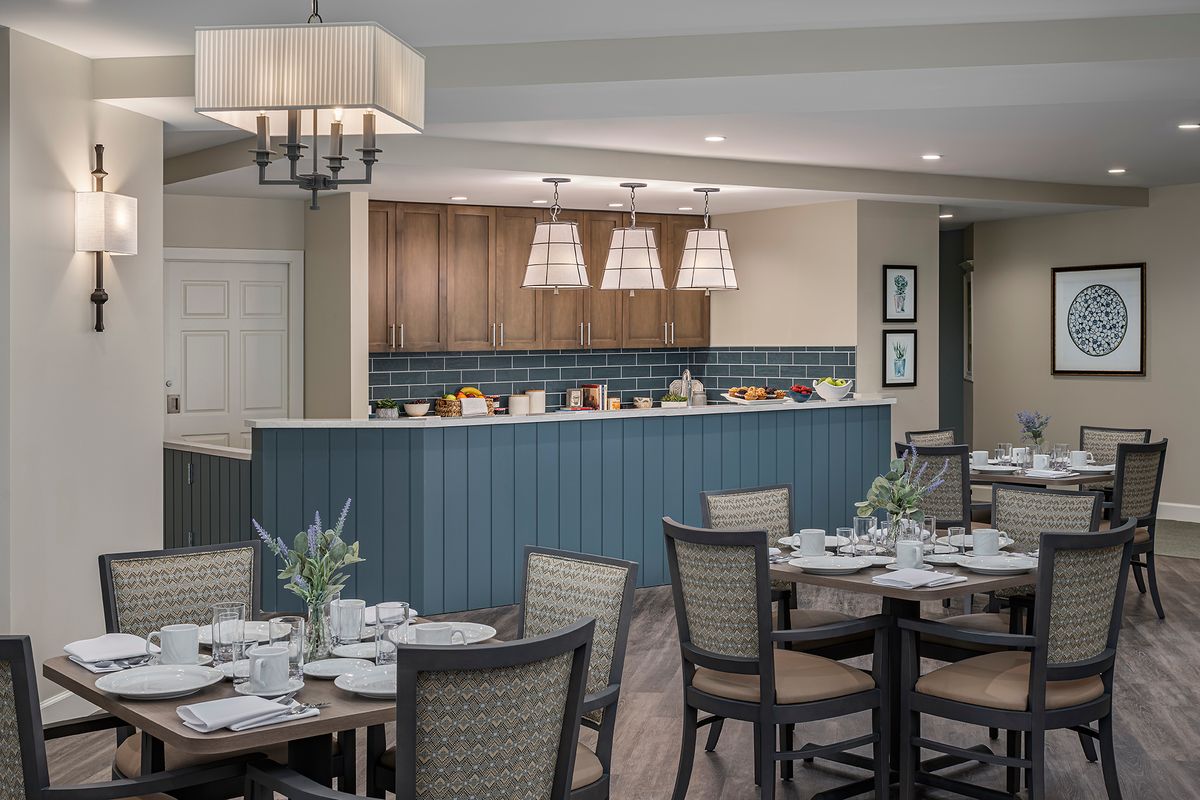 A modern dining area with elegantly set tables and pendant lighting.
