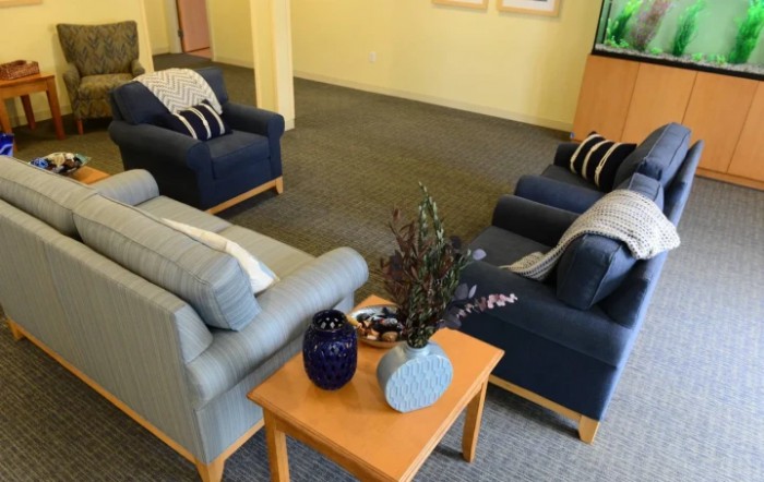 A cozy living room with multiple sofas and a coffee table adorned with decorative items.