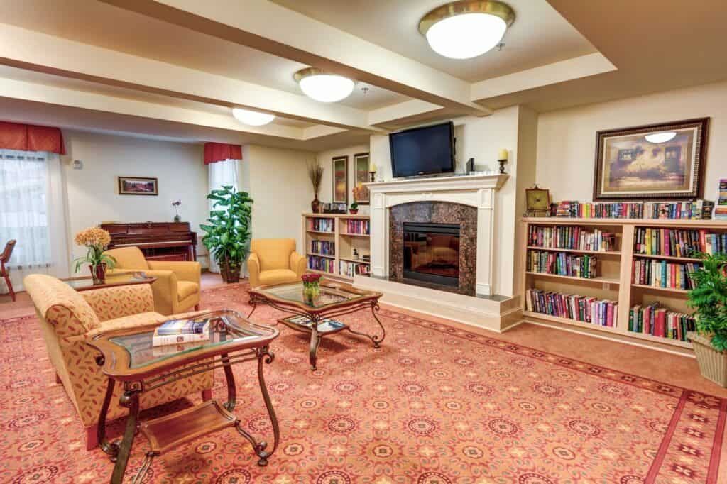 A cozy living room with a fireplace, bookshelves, and comfortable seating areas.