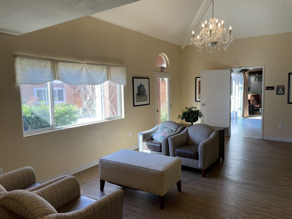 A cozy living room with comfortable seating and elegant chandelier lighting.