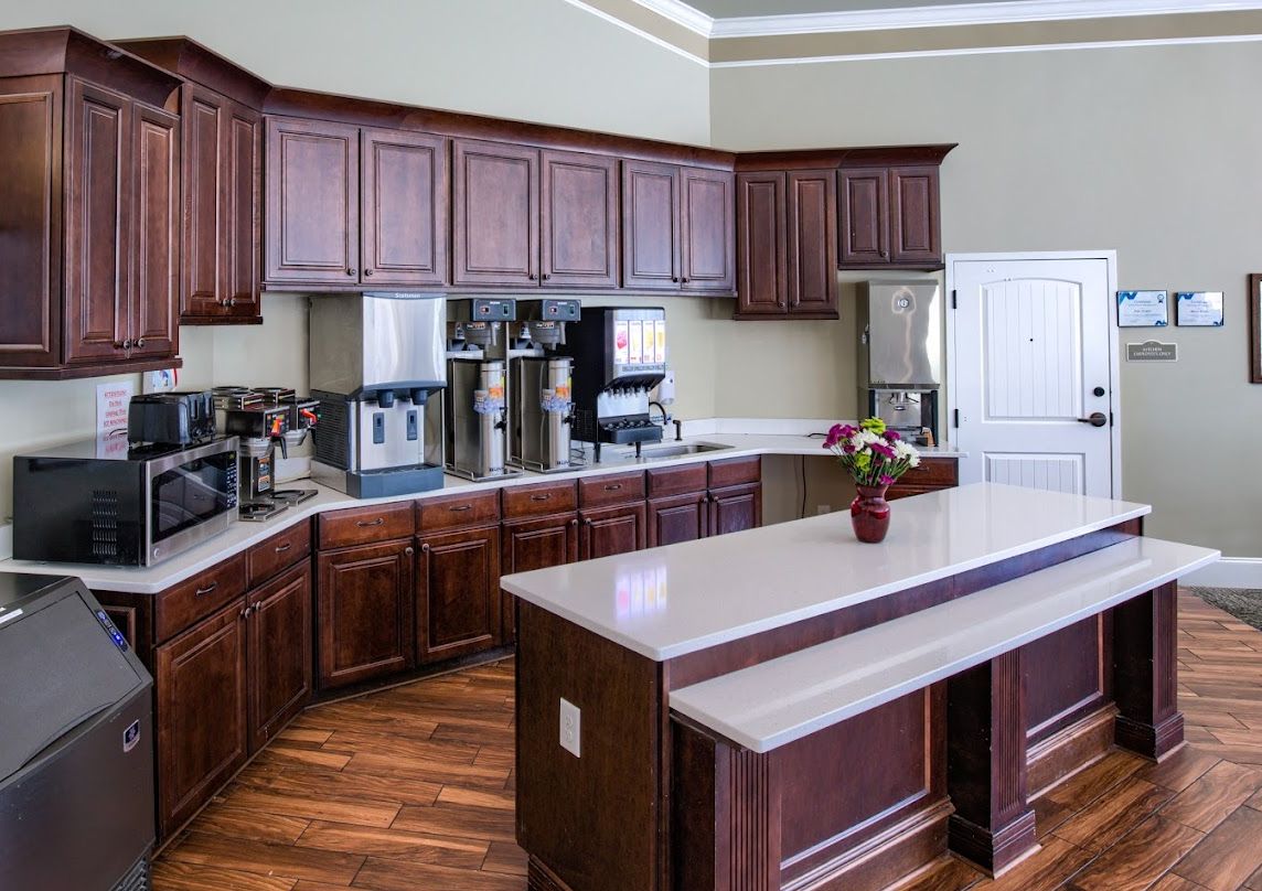 A modern kitchen with wooden cabinets, stainless steel appliances, and a central island.