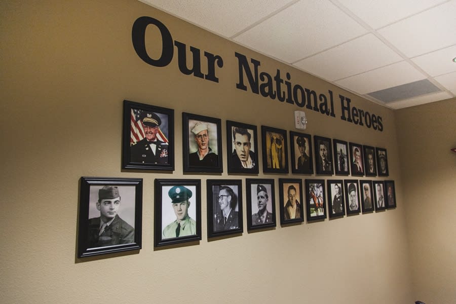 A wall featuring photographs of national military heroes as a tribute to veterans.