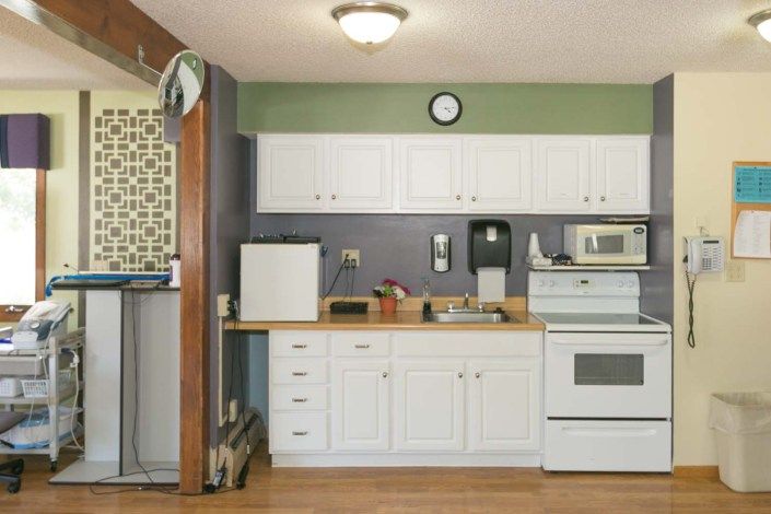 A modern kitchen with white cabinets and various appliances.