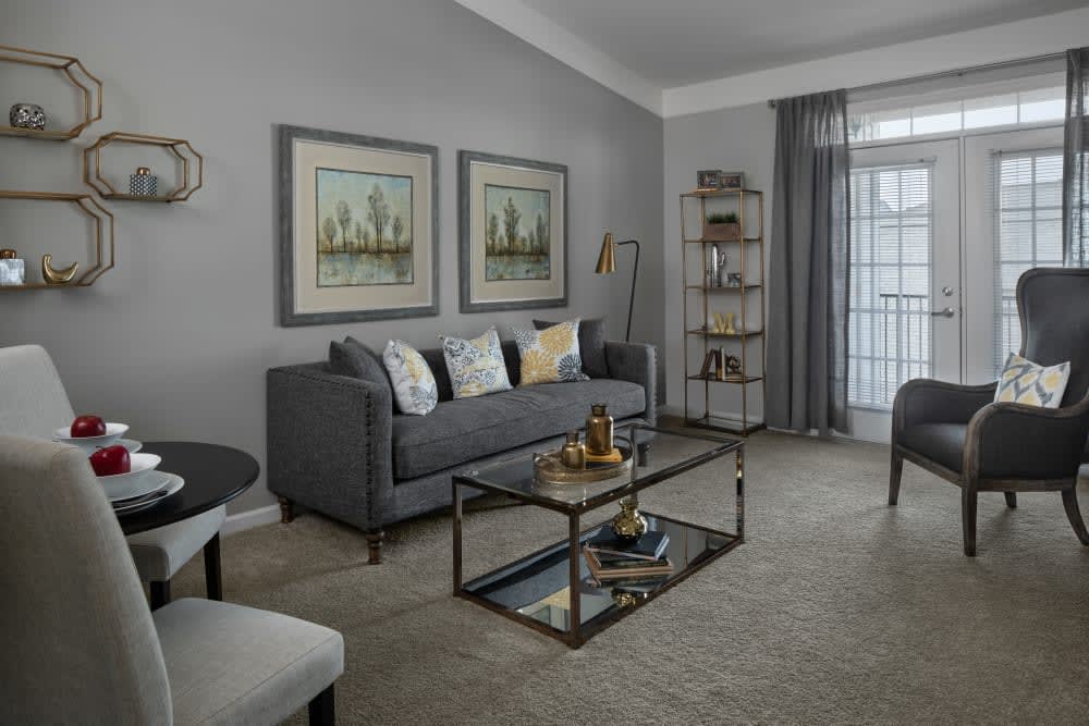 A modern living room with a gray color scheme, featuring a sleek sofa, decorative artwork, and stylish furniture.