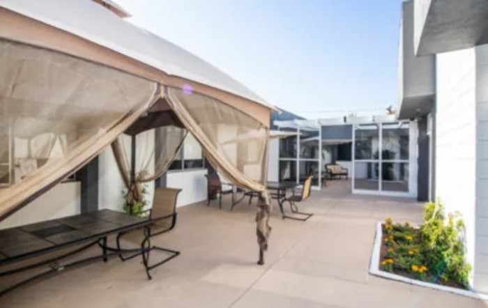 A spacious patio with comfortable outdoor seating and a canopy for shade.