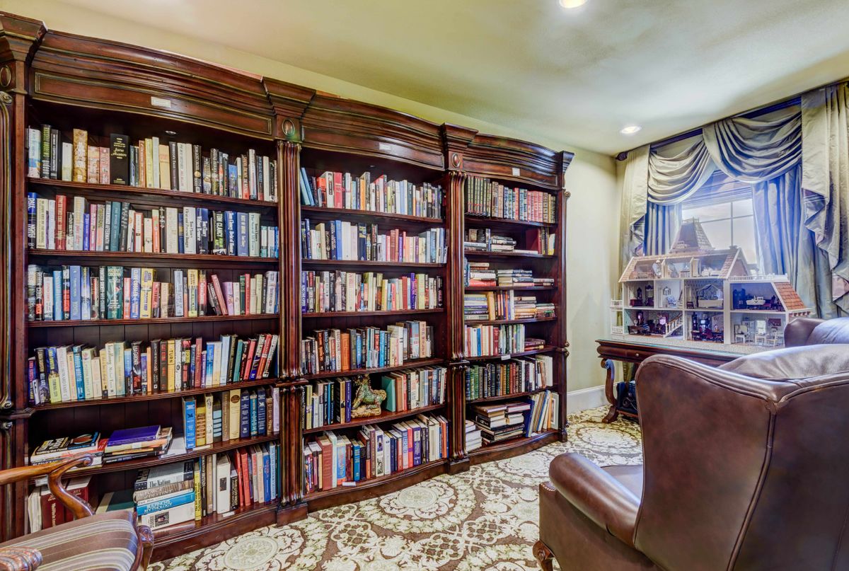 A cozy home library with bookshelves filled with a diverse collection of books.