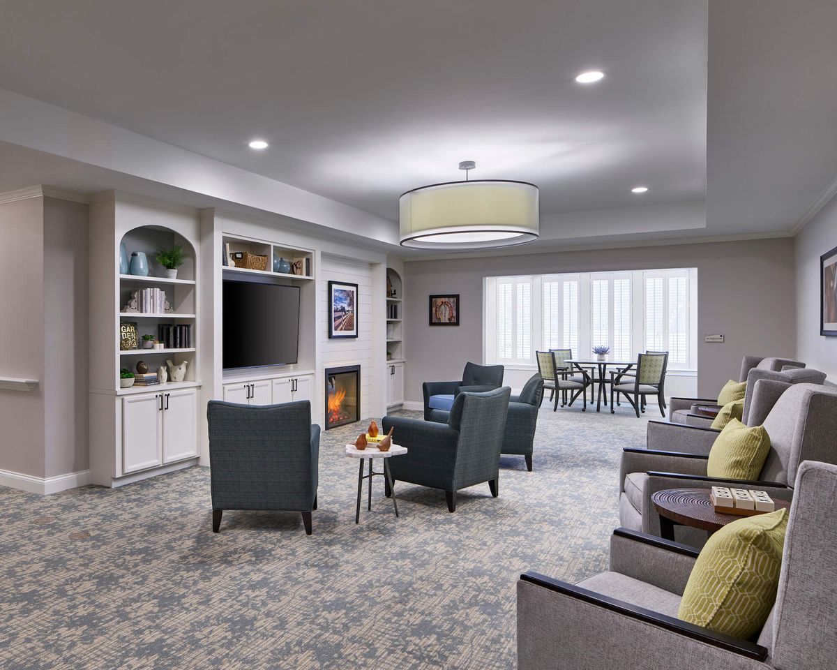 A modern living room with cozy seating, a fireplace, and built-in bookshelves.