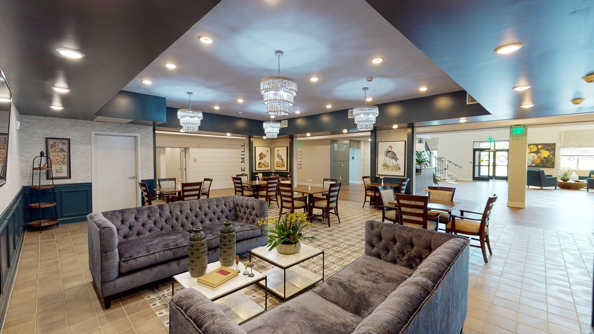 A luxurious lounge featuring elegant sofas, chandeliers, and a modern design.
