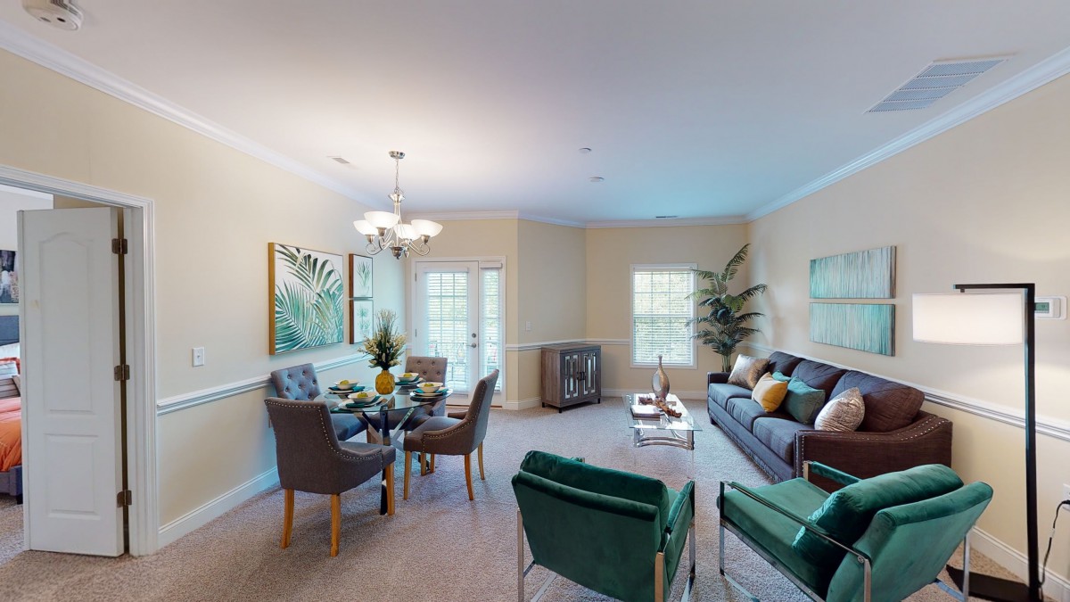 A modern living room with a cozy dining area, featuring stylish furniture and decor.