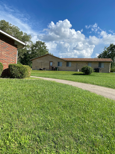 A serene residential scene with well-maintained grass and a clear blue sky.