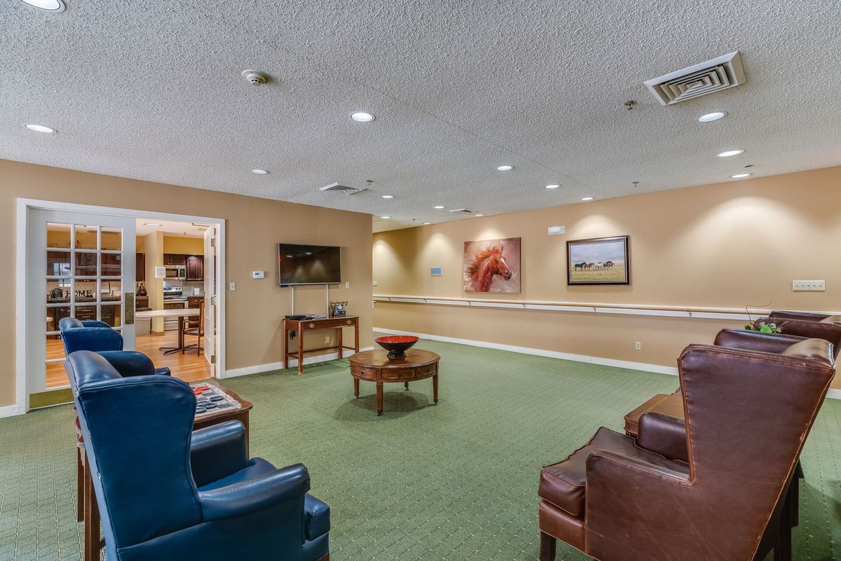 A cozy lobby area with comfortable seating, artwork on the walls, and a television.