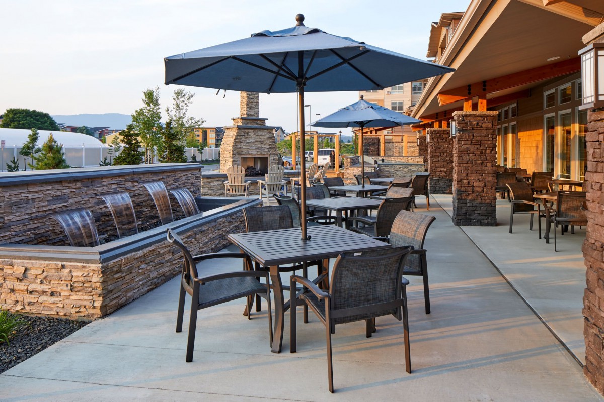 A patio area with tables, chairs, and umbrellas, perfect for outdoor dining on a sunny day.