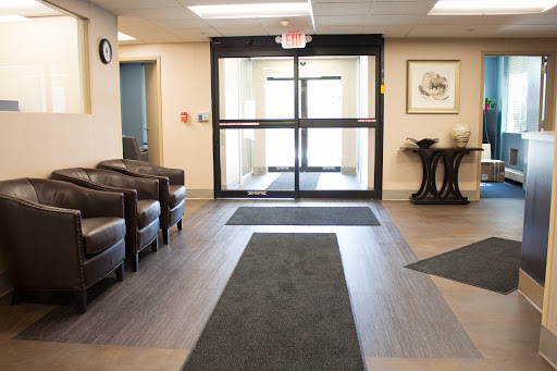 A spacious lobby area featuring comfortable seating and large glass doors.