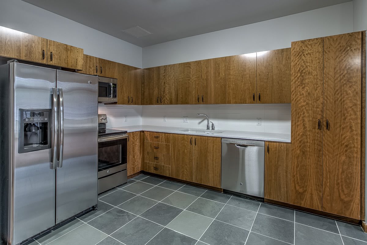 A modern kitchen with stainless steel appliances and wooden cabinets.