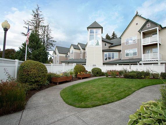 A residential building with landscaped gardens and a curved pathway.