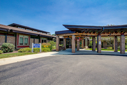 Modern healthcare facility entrance surrounded by landscaped gardens.