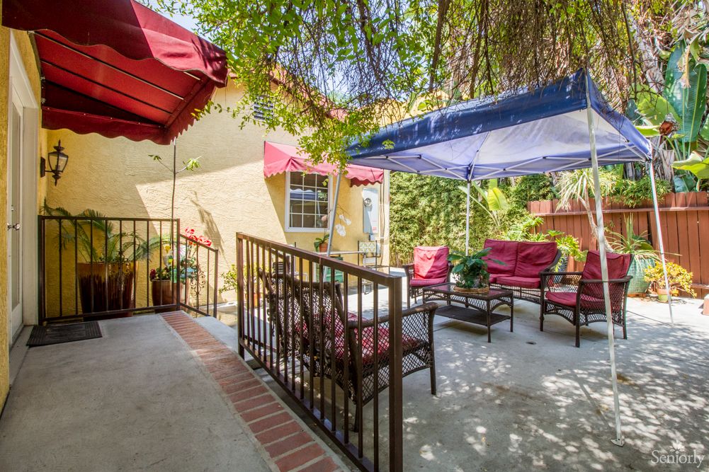 A cozy outdoor patio with comfortable seating and a canopy for shade.