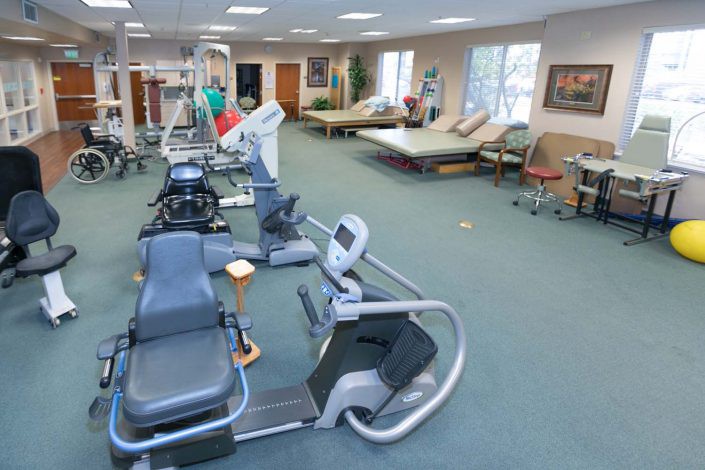 A rehabilitation center equipped with exercise machines and therapy beds.