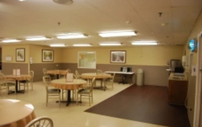 A clean and well-lit dining area with tables and chairs arranged neatly.