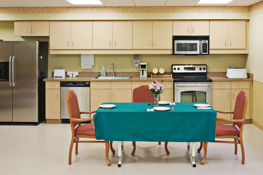 A cozy kitchen dining area featuring a green tablecloth, set for a meal.