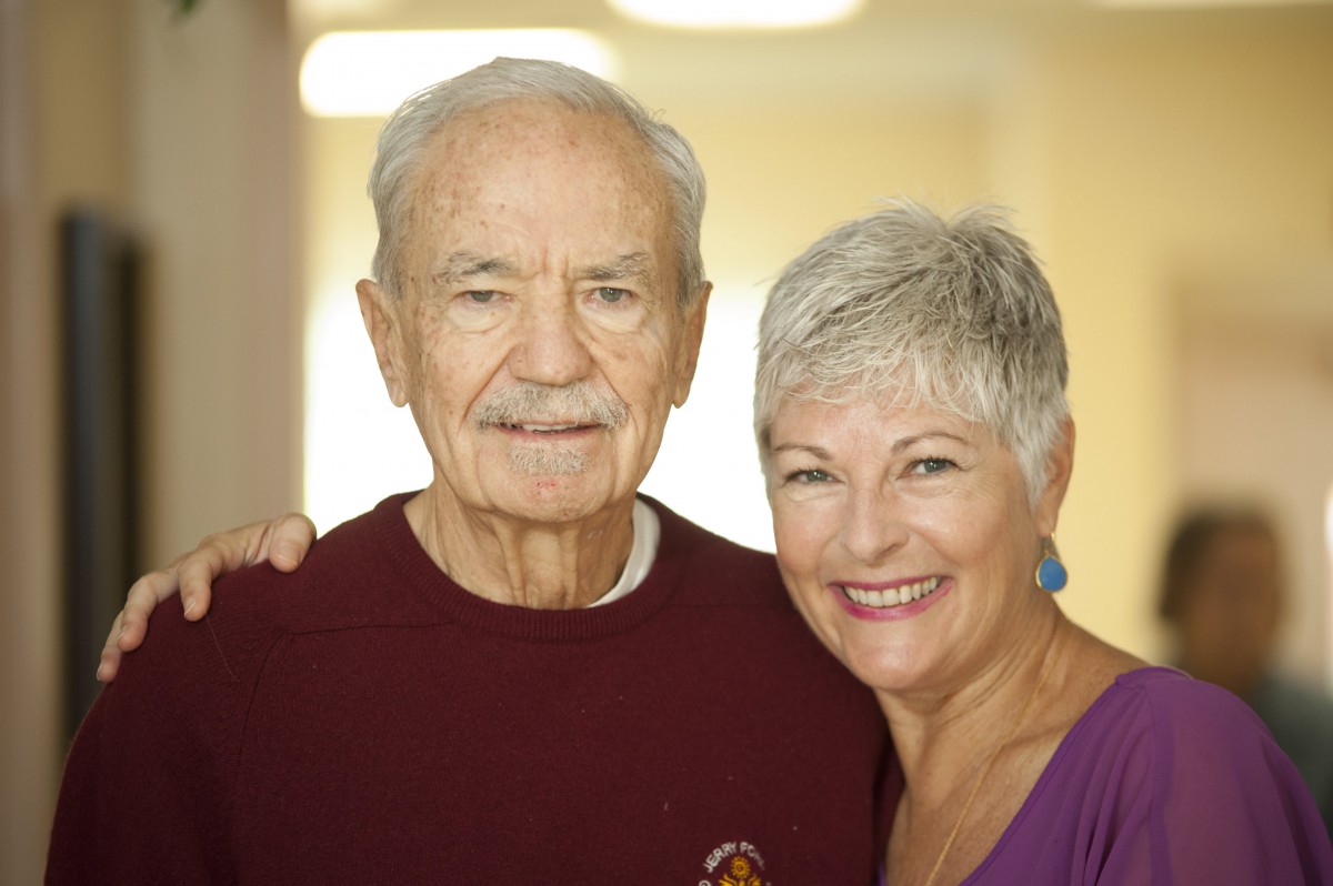 An elderly couple smiling indoors.